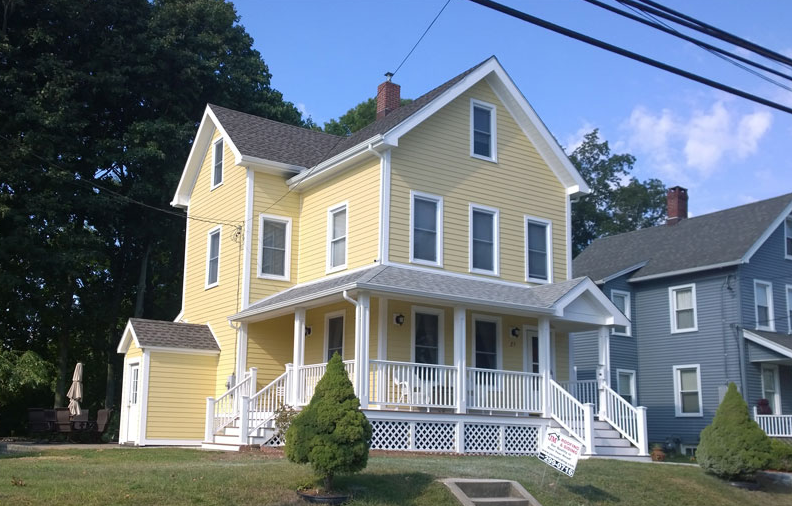 A home with yellow siding done by JM Roofing