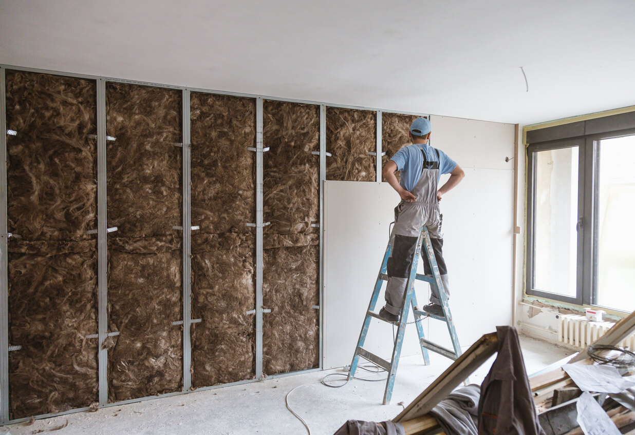 Man working on interior walls of home