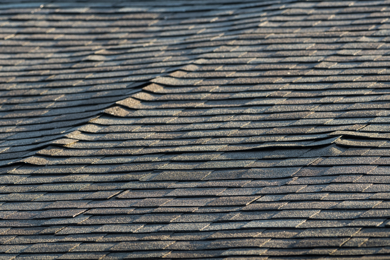A residential asphalt shingled roof with some issues that can be damaging to the house.