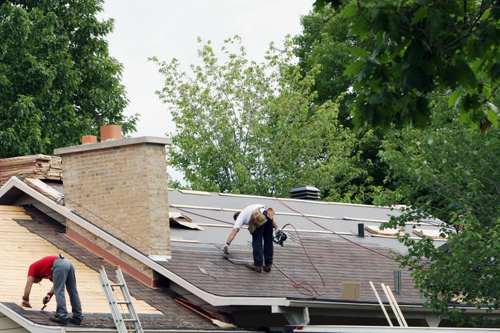 Men installing a new roof on a house.