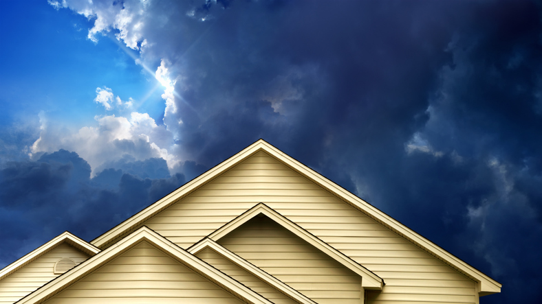 Close up rooftop of wooden house over over stormy sky